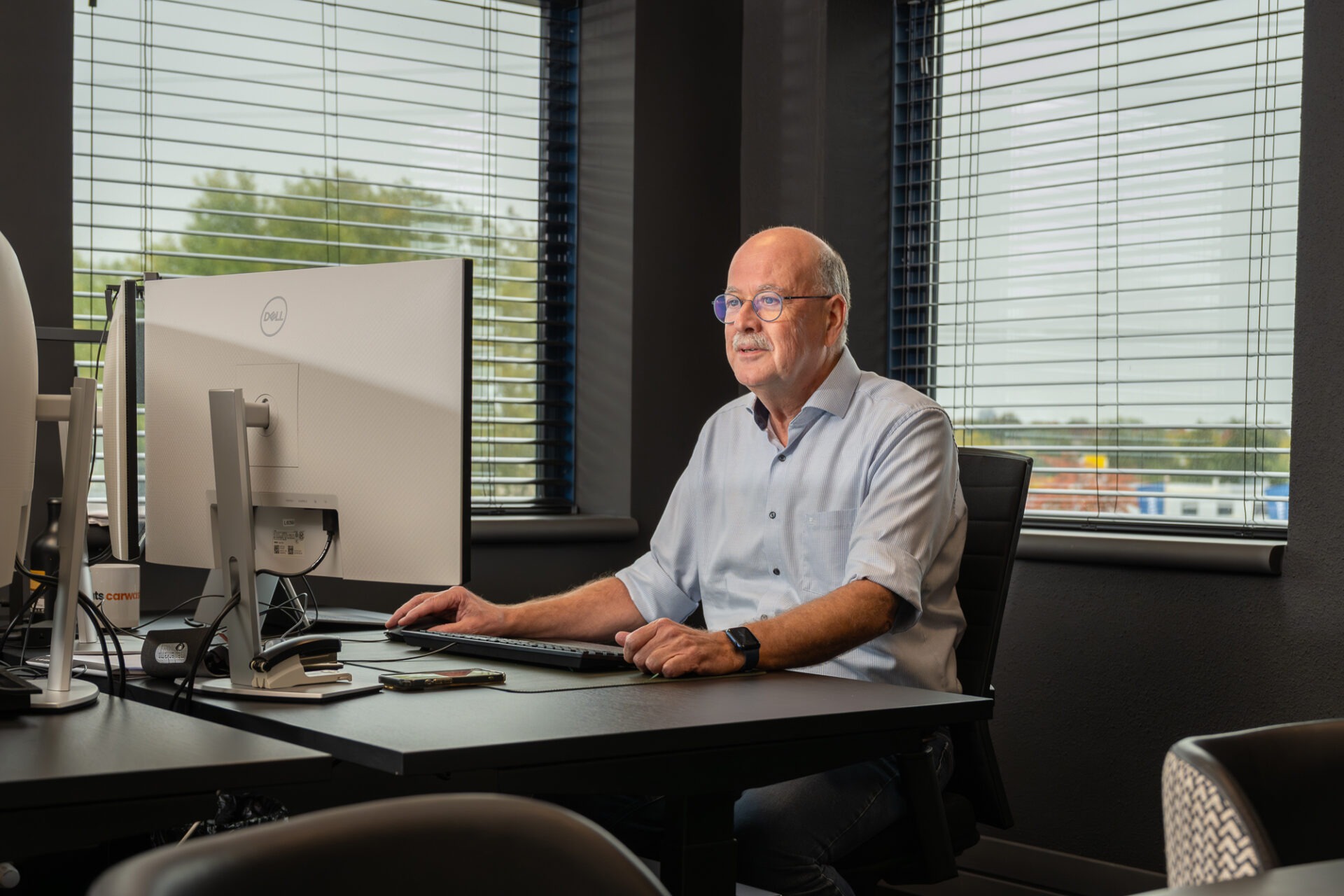 Senior ADA specialist werkt achter zijn computer aan betrouwbare bedrijfssoftware met aandacht voor kwaliteit en beheer.